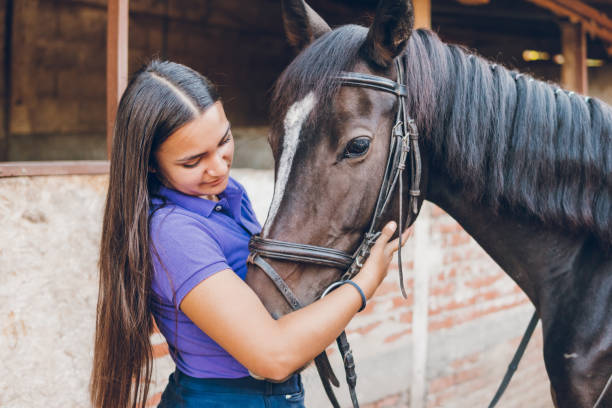 istock Young woman with her horse in a barn 1778692585