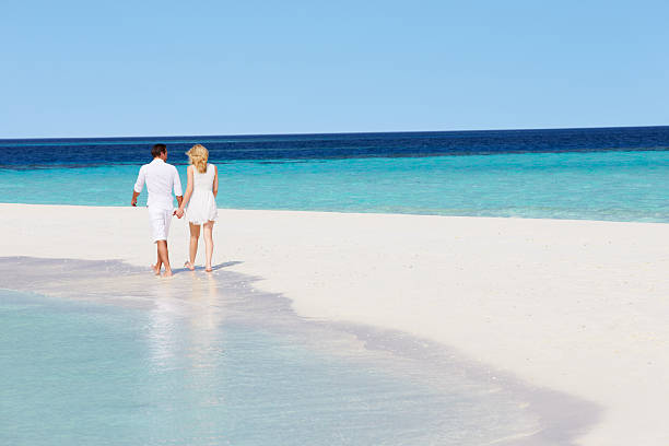 istock Rear View Of Romantic Couple Walking On Tropical Beach 177869405