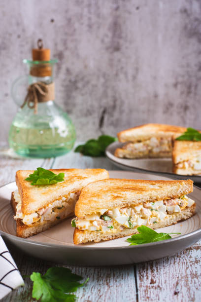 istock Chopped sandwiches with egg, bacon and herbs salad on a plate on the table vertical view 1778694905