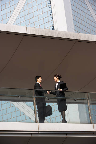 istock Two Business Colleagues Shaking Hands Outside Office Building 177869563