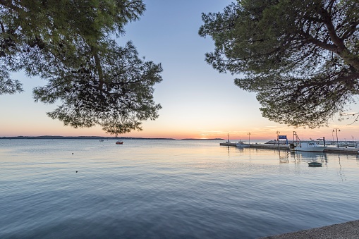 Sunset over the harbor of the Croatian port town of Fazana with a view of the Brijuni Islands in summer