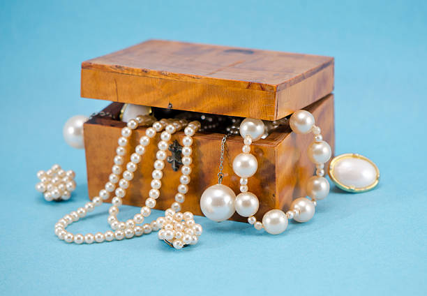 perla defocus in scatola in legno stile retrò su sfondo blu - pearl necklace earring jewelry foto e immagini stock