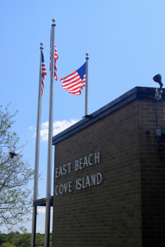 building at Cove Island beach with three American flags
