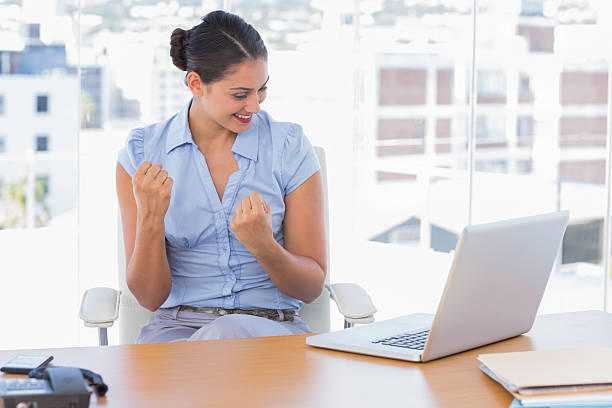 brunette geschäftsfrau jubeln vor ihrem laptop - office chair cheering ecstatic success stock-fotos und bilder