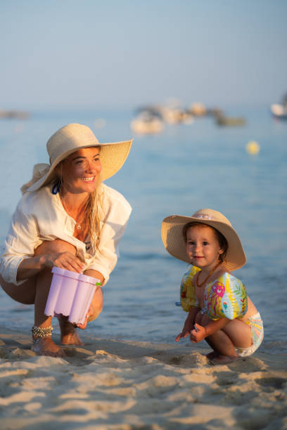 istock Mother and daughter playing whit sand on the beach 1778719375