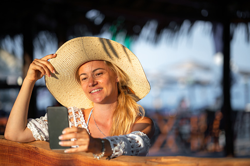 Happy woman using mobile phone during summer day