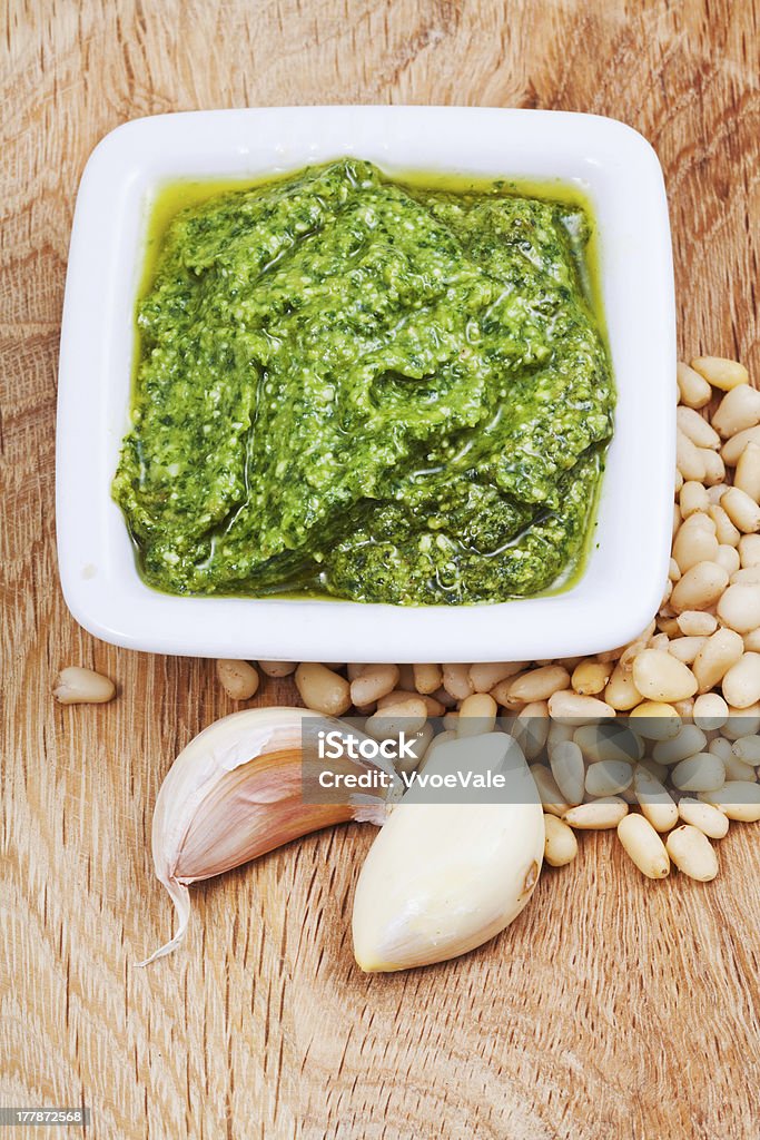 italian pesto con tuercas y ajo en tablero de madera - Foto de stock de Aceite de oliva libre de derechos