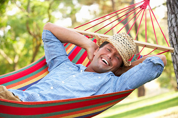 istock Smiling man relaxing in a colorful hammock 177875232