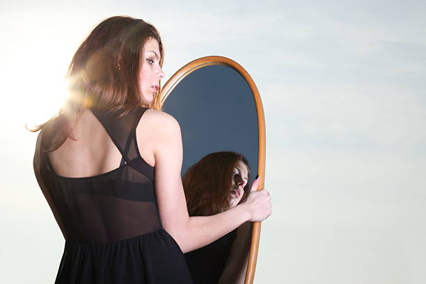 istock thoughtful woman looks at the reflection in mirror 177876054