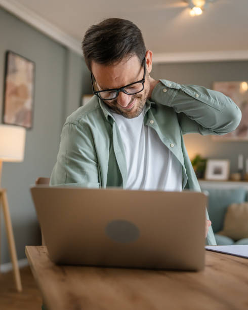 istock One man freelancer stretch while sitting at home work in chair at desk using laptop computer having pain sore back suffering from neck ache overwork and exhaustion concept copy space 1778764528
