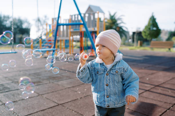 istock Little girl blowing soap bubbles on the playground 1778773067