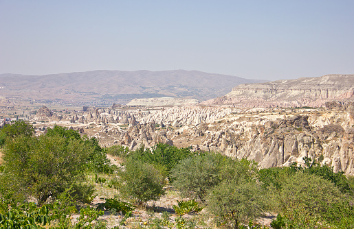 Panorama of unique geological formations in Cappadocia, Turkey. There is a group of tourists looking the scenics of the natural rock formations in Cappadocia.
