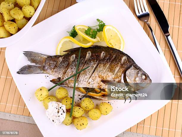 Grilled Fish Served With Potatoes Lemon And Sauce Stock Photo - Download Image Now - Carp, Citrus Fruit, Cooked