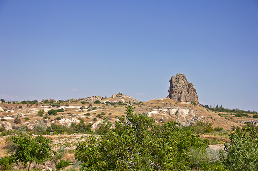 Panorama of unique geological formations in Cappadocia, Turkey. There is a group of tourists looking the scenics of the natural rock formations in Cappadocia.