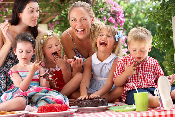 お子様やケーキを食べる女性屋外でのティーパーティ - birthday family party cake ストックフォトと画像