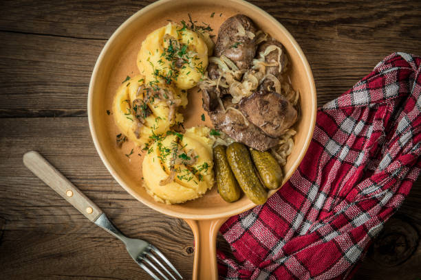 istock Fried chicken liver with onion served with mashed potatoes and pickled cucumber. 1778795336