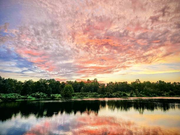 istock a beautiful sunset over a lake surrounded by trees and bushes 1778806061