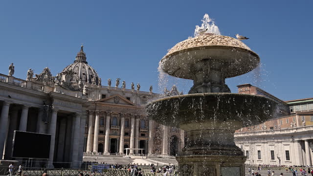 Vatican City. Statues in St. Peter's Basilica, Maderno Fountain against St. Peter's Basilica, Water splashing from the fountain in St. Peter's Square in Rome on a sunny day, Piazza San Pietro (St. Peter's Square)