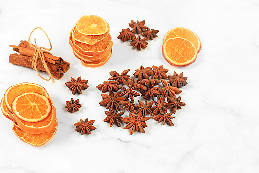 Kitchen background, composition with traditional winter spices to boost immunity during the cold period. Star anise, cinnamon, dried oranges and tangerines with spruce branches. New Year's Eve and Christmas concept, selective focus