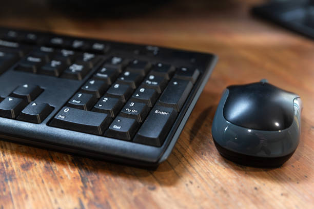 istock Black mouse and keyboard upon a wooden desk 1778856529