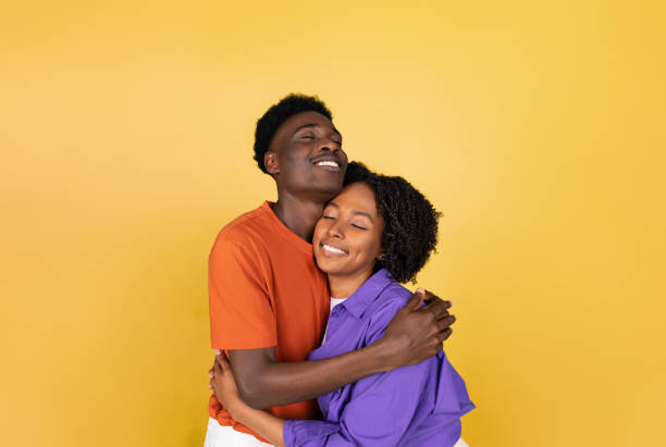 istock Happy millennial black guy hugging lady, enjoy love, isolated on yellow studio background 1778856532