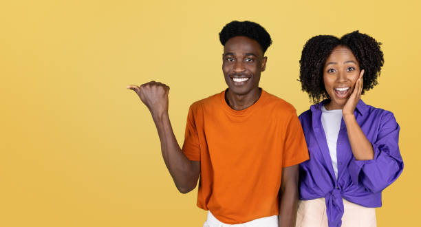istock Positive surprised millennial black couple in casual point hand on empty space 1778856553