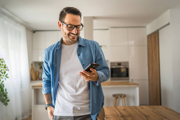 istock adult man with eyeglasses stand at home use mobile phone sms texting 1778899218