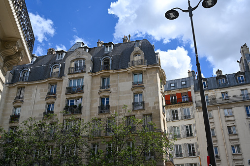 Paris, France. June 30 2022. Beautiful view of the houses of the historic center: charm and style of French architecture. On the right a street lamp.
