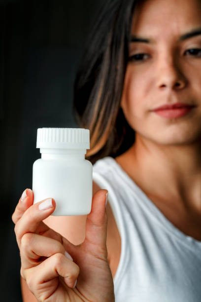 istock Hispanic woman holding blank pill bottle with copy space 1778924050