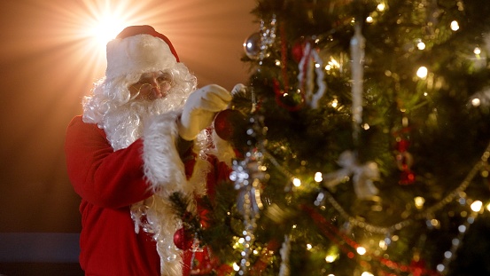 Santa Claus decorates the Christmas tree. Close-up of Santa Claus decorating the Christmas tree.