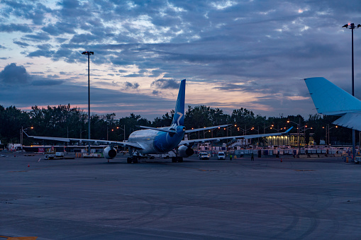 An Air Transat airplane taxiing on the runway of Toronto Pearson International Airport at dusk, Ontario, Canada.