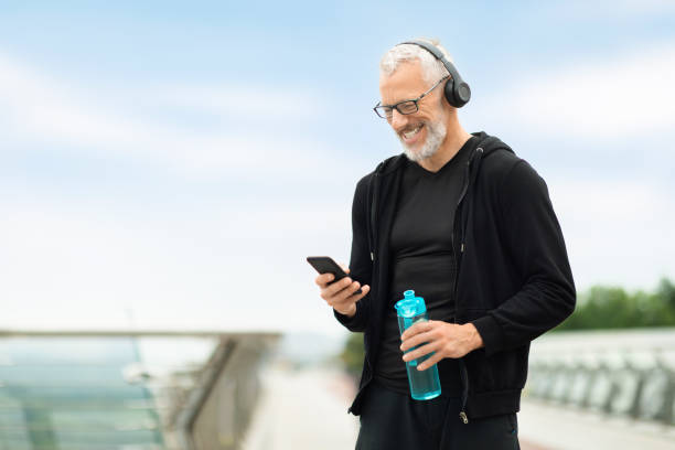 istock Retired sportsman using phone while resting after workout, drinking water 1778925477