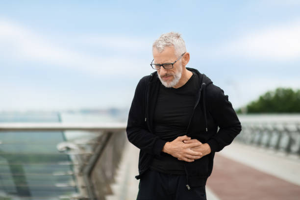 istock Senior sportsman exercising outdoor, standing on bridge, touching left side 1778925607