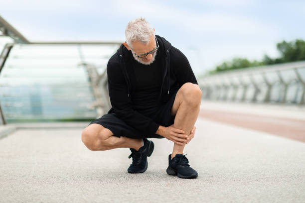 istock Senior man jogging by bridge, suffering from shin splint 1778925648
