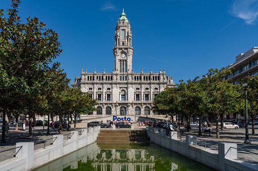 People are visiting the town square. Porto City Hall (Pacos do Concelho) and City Sign - Porto, Portugal.