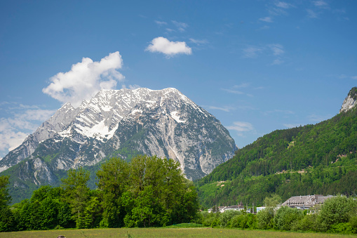 Summer austrian landscape with green meadows and Grimming mountain (2.351 m), an isolated peak in the Dachstein Mountains, in Styria region, Austria