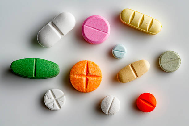 Health themes: Large group of assorted capsules and pills on white background