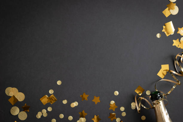 istock Gold confetti and champagne on black 1778931002