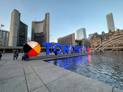 Toronto, Ontario, Canada - July 19 2021 : Fountain at Nathan Phillips Square. Toronto Sign. Toronto Old City Hall.