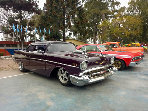 Lanús, Argentina - Sept 24, 2023: Old customized chopped red burgundy 1957 Chevrolet Chevy Bel Air sport sedan two door at a classic car show in the a park