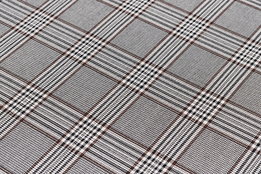 Close-up texture fabric of black with brown tartan checkered side view. Material for sewing skirts, shirts and coats. Background for your design