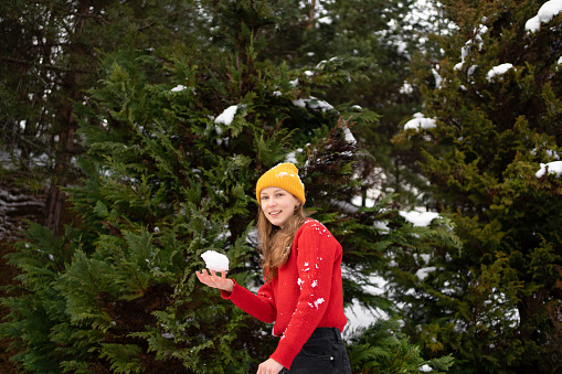 Portrait of a young woman about to throw a snowball during a snowball game