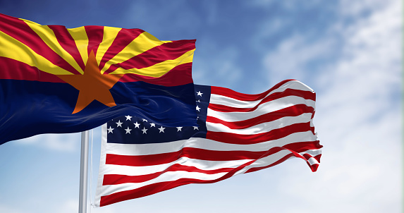 Flags of Arizona and United States waving in the wind on a clear day. Arizona is a state in the Southwestern US. US federate state. 3d illustration render. Fluttering textile