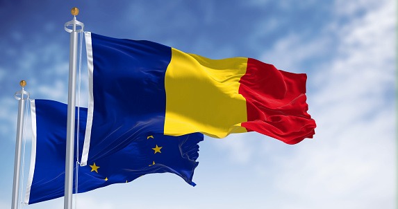 Romania and European Union flags waving in the wind on a clear day. Eu member since January 2007. 3d illustration render. Fluttering fabric