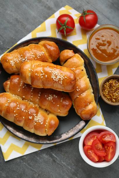 istock Delicious sausage rolls and ingredients on grey table, flat lay 1779049782