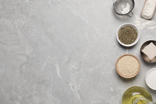 Cooking grissini. Different ingredients on grey marble table, flat lay. Space for text