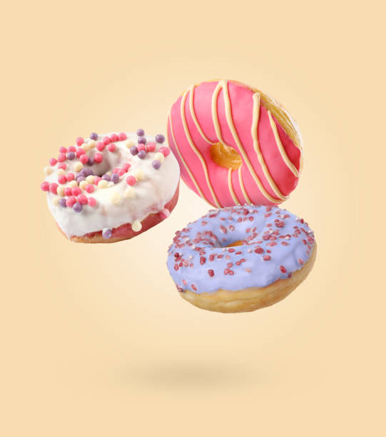 istock Sweet tasty donuts falling on beige background 1779051360