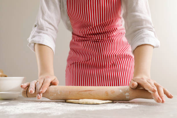 istock Woman rolling fresh dough at light grey table, closeup. Cooking grissini 1779051378