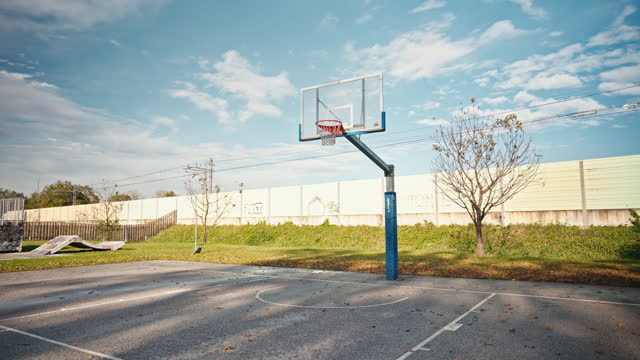 SLO MO Basketball Hoop at Sports Court Under Blue Sky on Sunny Day