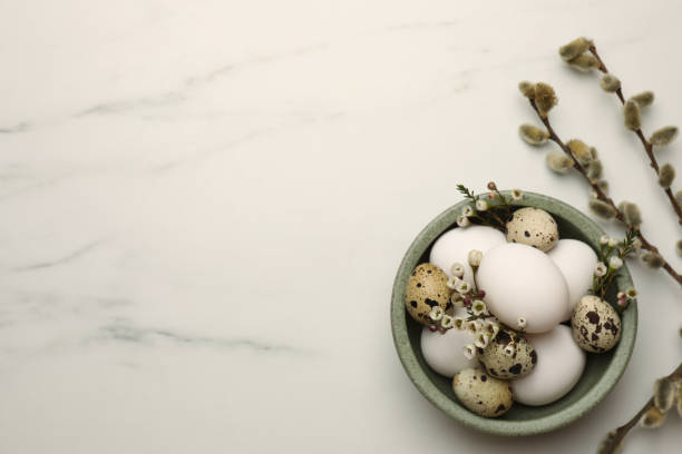 istock Easter eggs, flowers and pussy willow branches on white marble table, flat lay. Space for text 1779064760
